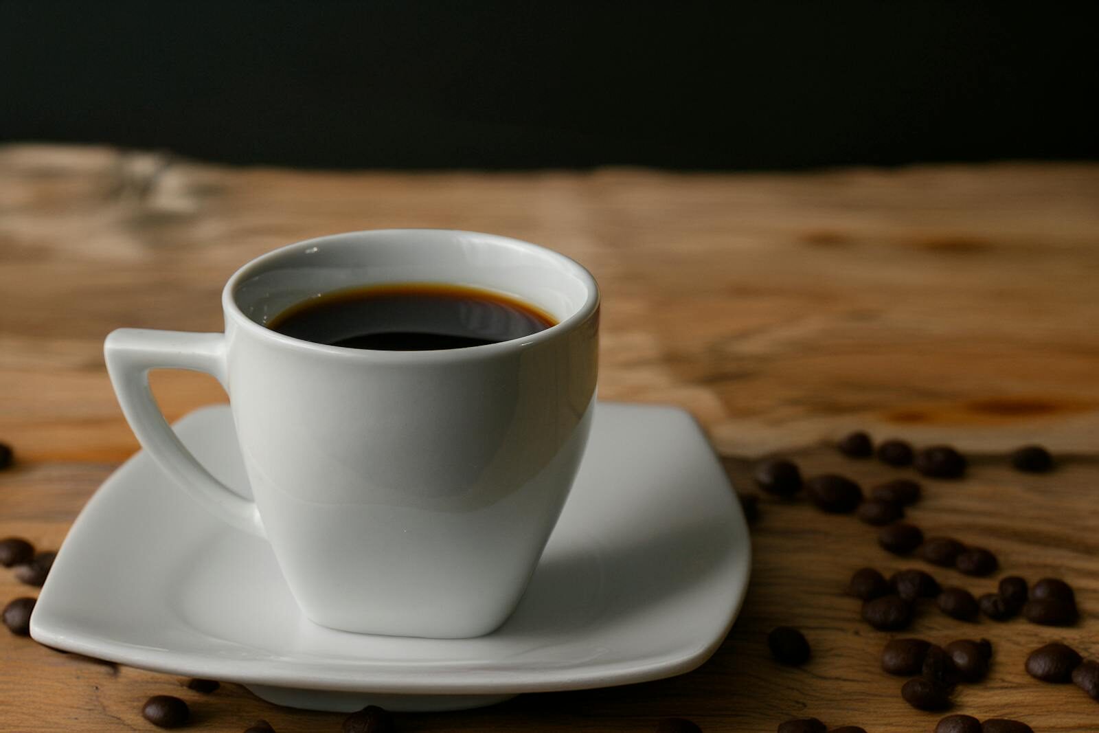 A minimalist cup of black coffee on a rustic wooden table in Perú.